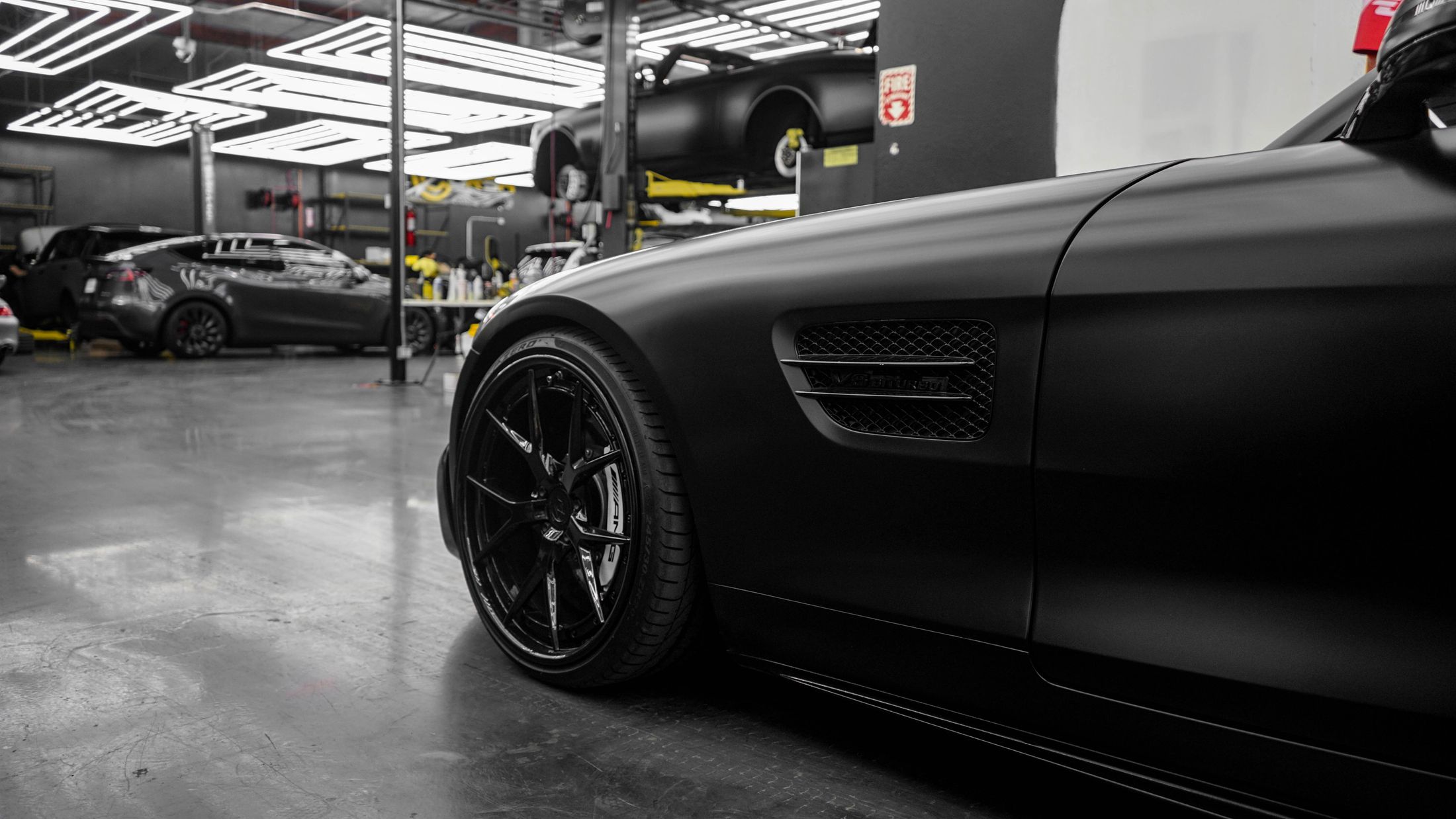 Black performance coupe in a focused automotive workshop